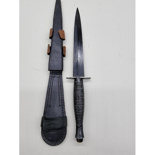 1597 - A Fairbairn Sykes style fighting knife and leather sheath, with 17.5cm blade.