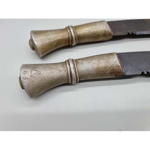 1600 - An unusual pair of metal handled kukris, one handle inscribed 'F G 579', with 34cm and 35cm blades r... 