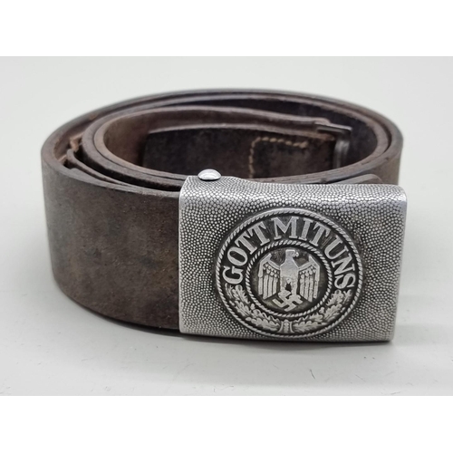 1605 - A German Third Reich Wehrmacht leather belt and buckle, the aluminium buckle inscribed 'Gott Mi... 