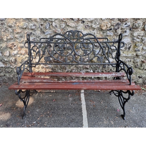 1633 - A cast iron garden bench, with wood slats, 122cm wide.