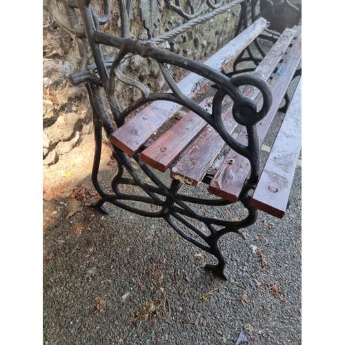 1633 - A cast iron garden bench, with wood slats, 122cm wide.