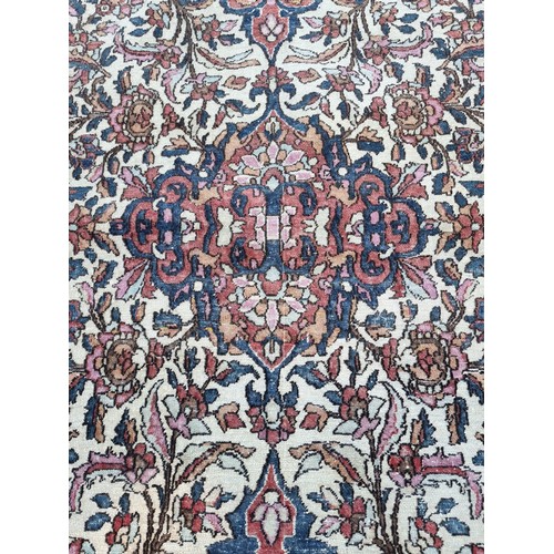 1000 - A Persian rug, having central floral cartouche, on cream ground with floral borders, 210 x 135cm.... 