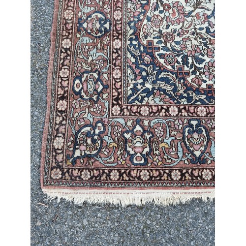 1000 - A Persian rug, having central floral cartouche, on cream ground with floral borders, 210 x 135cm.... 