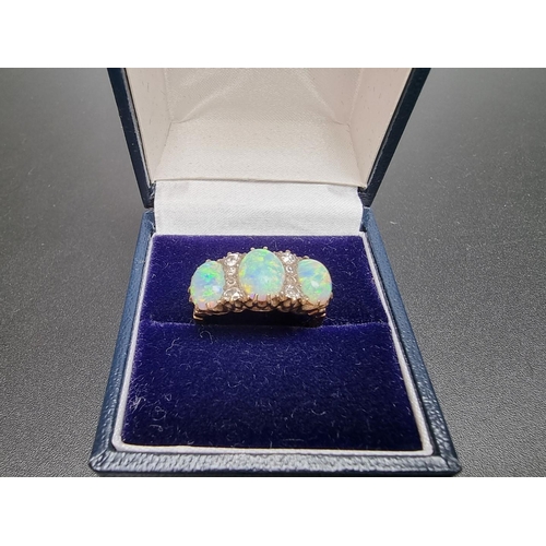 174 - A yellow metal ring, set three cabochon opals and eight graduated mine cut diamonds, size O.... 