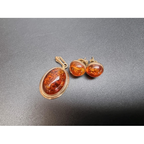 186 - A pair of 9ct gold amber stud earrings; together with a 9ct gold amber pendant. (3)