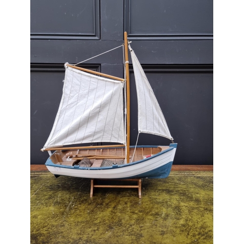 1385 - A small painted wood model boat, the hull 39cm long, on stand. 