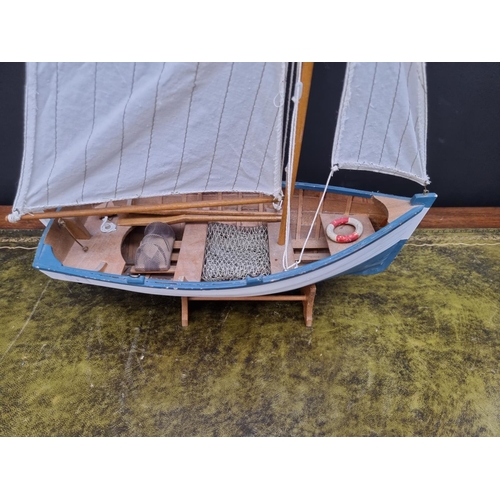 1385 - A small painted wood model boat, the hull 39cm long, on stand. 