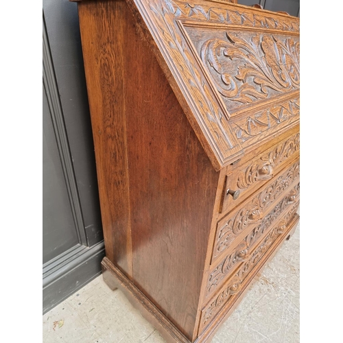 1027 - A late 19th/early 20th century carved oak bureau, 91cm wide. 