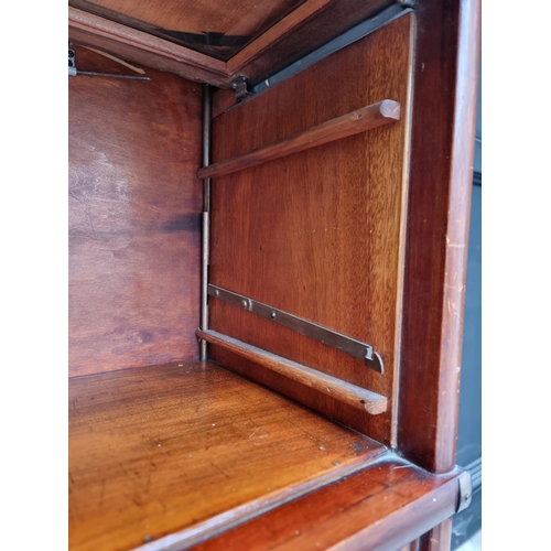 1033 - A good mahogany and crossbanded four tier sectional bookcase, with apron drawer and bevelled glass p... 
