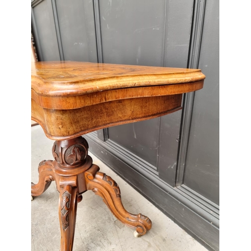 1047 - A Victorian figured and carved walnut pedestal card table, 89cm wide.
