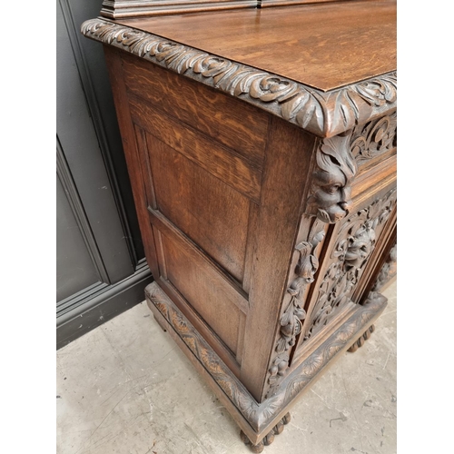 1067 - A large late Victorian carved oak side cabinet, 199cm wide.