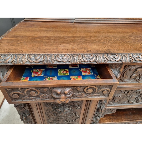 1067 - A large late Victorian carved oak side cabinet, 199cm wide.