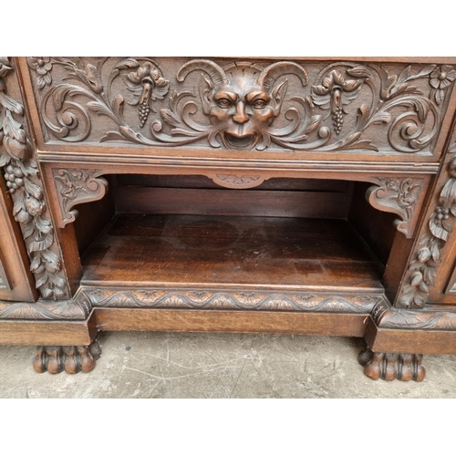 1067 - A large late Victorian carved oak side cabinet, 199cm wide.