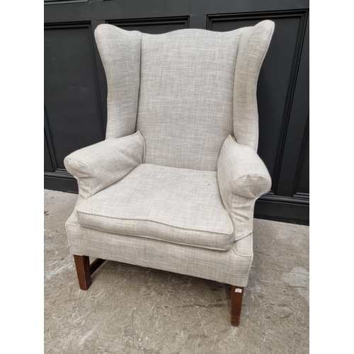 1073 - A large antique mahogany and upholstered wing armchair. 