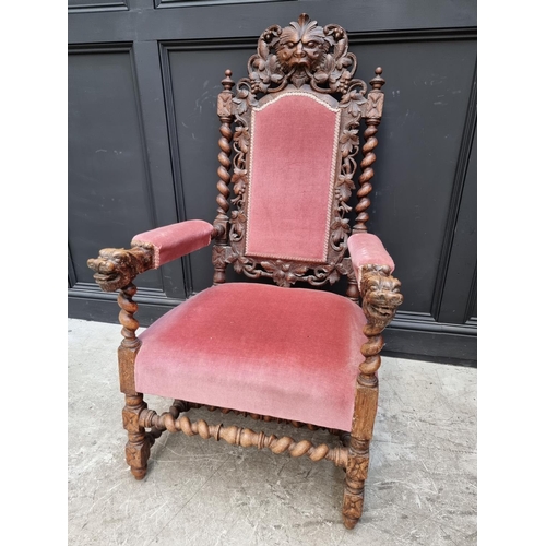 1077 - A late Victorian carved oak and upholstered open arm occasional chair. 