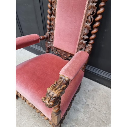 1077 - A late Victorian carved oak and upholstered open arm occasional chair. 