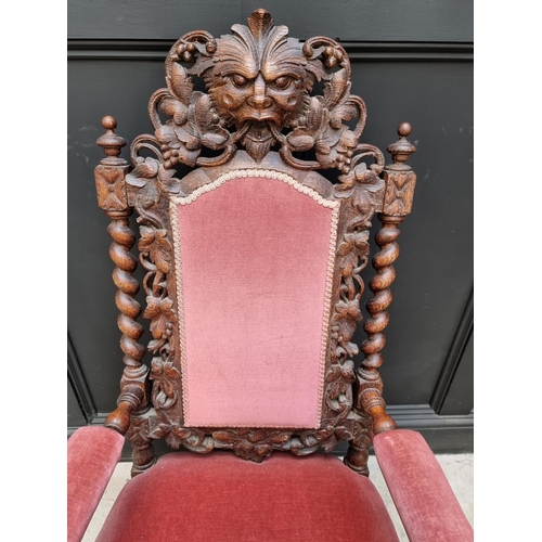 1077 - A late Victorian carved oak and upholstered open arm occasional chair. 