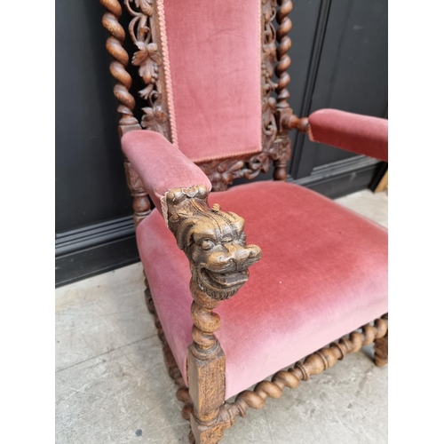 1077 - A late Victorian carved oak and upholstered open arm occasional chair. 