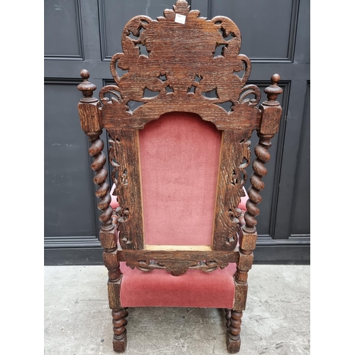 1077 - A late Victorian carved oak and upholstered open arm occasional chair. 