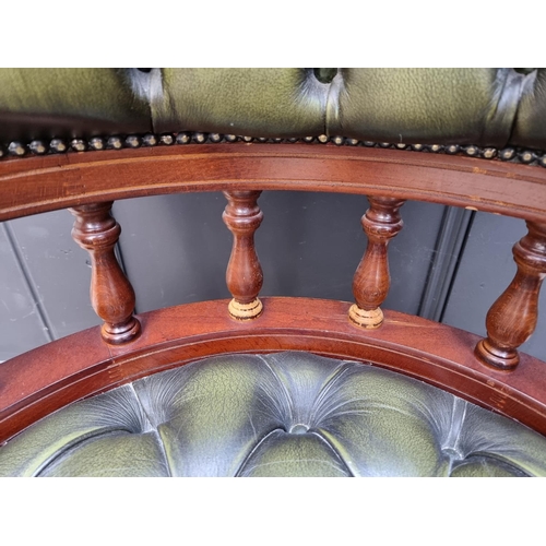 1079 - A buttoned green leather rotating adjustable desk chair.  