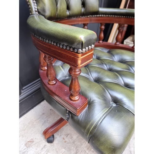 1079 - A buttoned green leather rotating adjustable desk chair.  