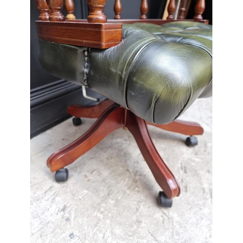 1079 - A buttoned green leather rotating adjustable desk chair.  