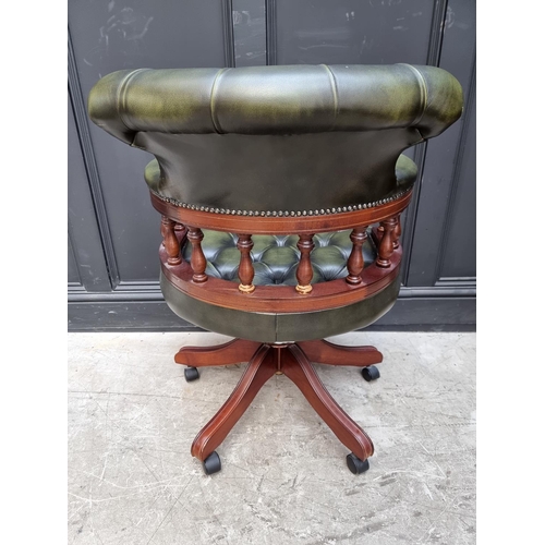 1079 - A buttoned green leather rotating adjustable desk chair.  