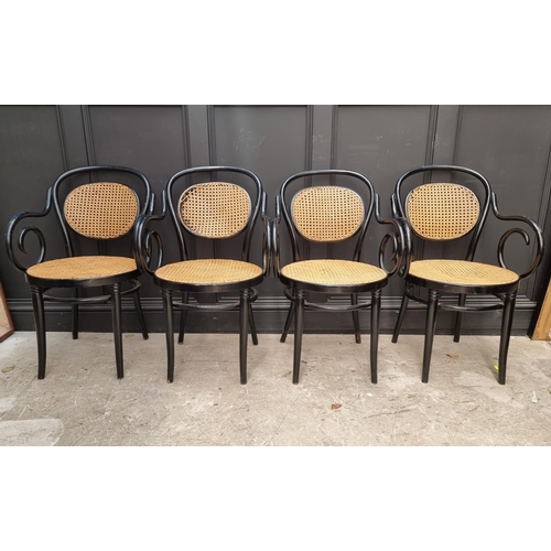 1085 - A set of four ebonized and cane bentwood elbow chairs, labelled 'Dinette'.