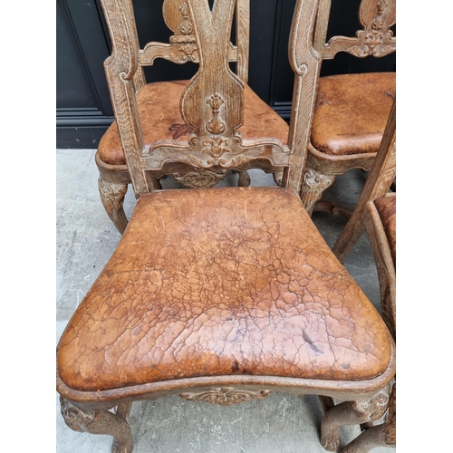 1088 - A set of six early 18th century style limed oak and tan leather dining chairs, with carved decoratio... 