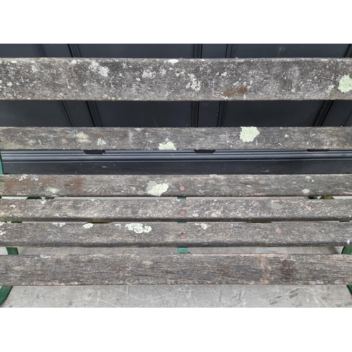 1107 - An old green painted wrought iron garden bench, 150cm wide. 