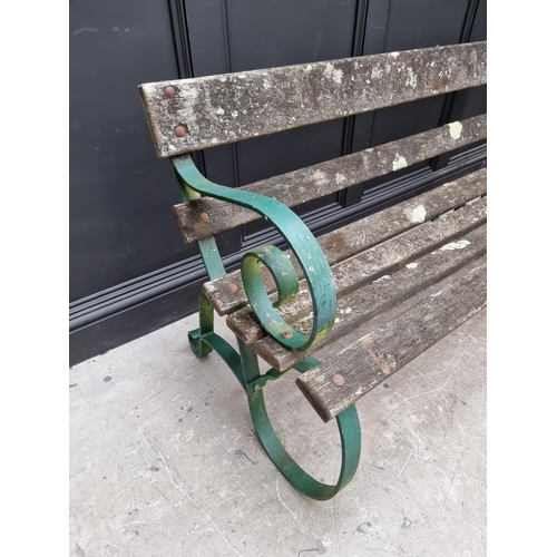 1107 - An old green painted wrought iron garden bench, 150cm wide. 