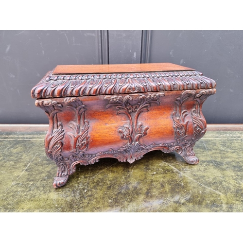 1112 - A reproduction carved hardwood bombe tea caddy and cover, in the rococo style, 30.5cm wide.... 