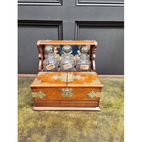 1119 - A circa 1900 oak and electroplate mounted combined tantalus, cigar and games box, the apron drawer w... 