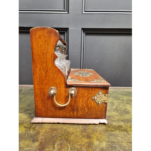 1119 - A circa 1900 oak and electroplate mounted combined tantalus, cigar and games box, the apron drawer w... 