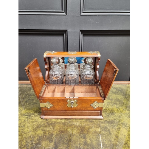 1119 - A circa 1900 oak and electroplate mounted combined tantalus, cigar and games box, the apron drawer w... 