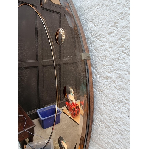 1262 - An Art Deco circular peach glass wall mirror, 61cm diameter.