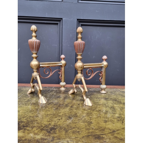 1300 - A pair of Aesthetic brass and copper andirons, 33cm high. 