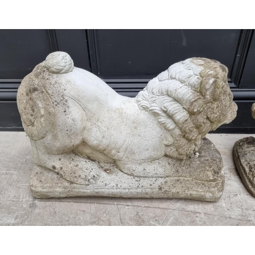 1355 - A pair of composition stone recumbent lions, 55cm long.