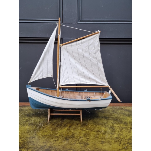 1385 - A small painted wood model boat, the hull 39cm long, on stand. 