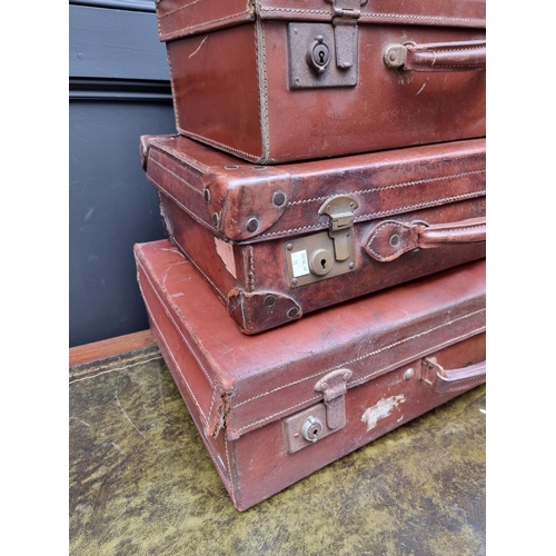 1416 - Three vintage leather suitcases, largest 66.5cm wide. 