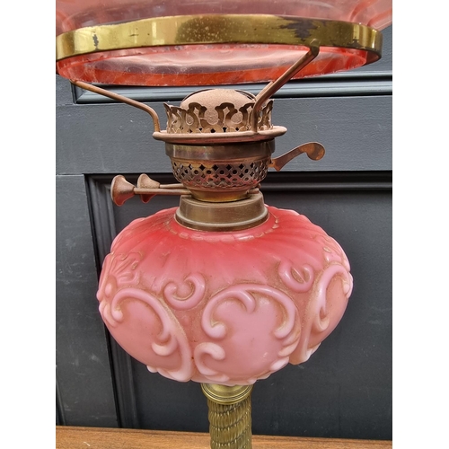 1423 - A Victorian brass and opaque glass oil lamp, with cranberry shade, 72.5cm high, (lacking chimne... 