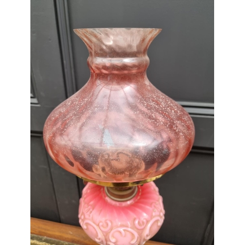 1423 - A Victorian brass and opaque glass oil lamp, with cranberry shade, 72.5cm high, (lacking chimne... 