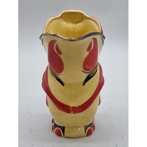 1435 - An Art Deco pottery elephant jug, 23cm high; together with a Clarice Cliff preserve pot and cov... 