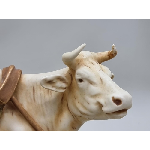 1453 - A Royal Dux figure group of a farmer and cow, 37cm wide.