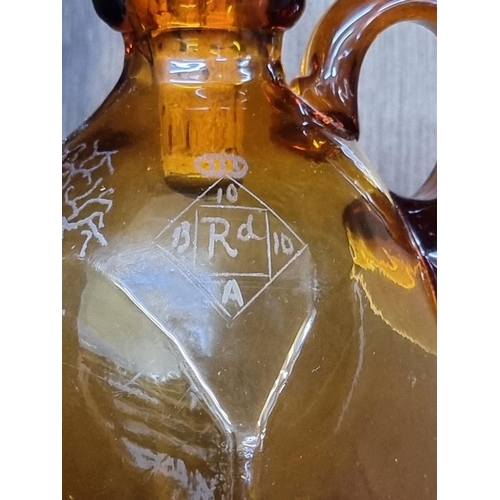 1543 - A Victorian amber glass whisky jug and mother of pearl stopper, with etched registration lozenge, he... 