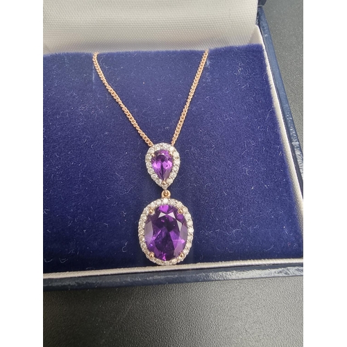 139 - An 18ct gold amethyst and diamond pendant on a 9ct gold chain, each amethyst surrounded by a border ... 