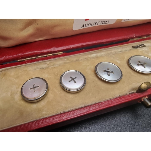 145 - A cased set of six mother of pearl buttons, two largest stamped '18ct'.