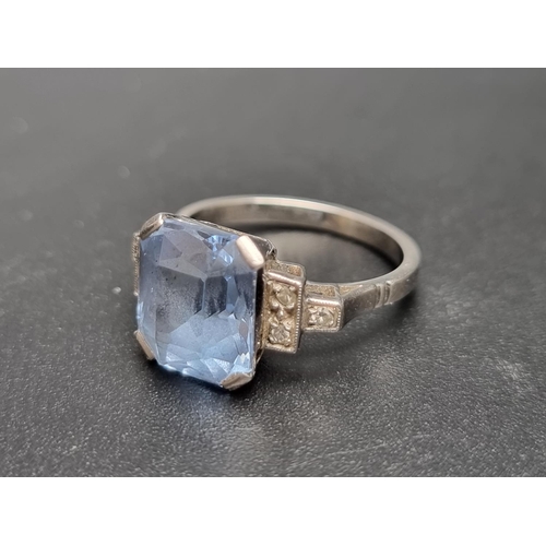 154 - An Art Deco white metal ring, set facetted blue topaz with three small diamonds to each shoulder, si... 