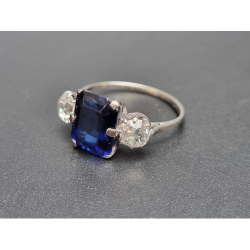 162 - A white metal synthetic sapphire and diamond three stone ring, set central sapphire and two old cut ... 