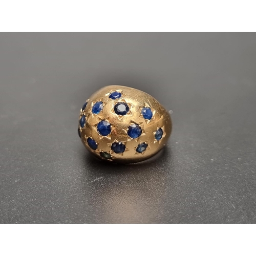 163 - A yellow metal ring, of domed design pave set fifteen sapphires, size J.